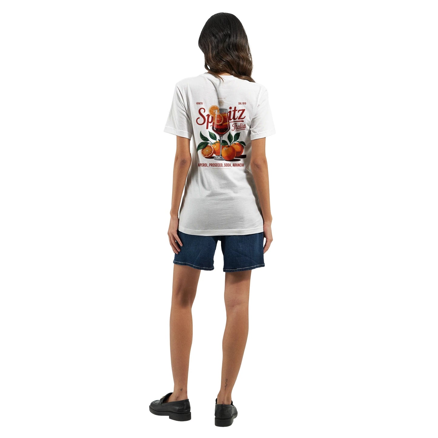frau trägt spritziges sommer t-shirt mit orangen-print auf rückseite, kombiniert mit jeans-shorts.