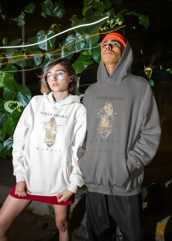 Zwei Personen tragen Pullover Hoodie Sommer Feeling Hawaii aus Baumwoll-Polyester-Mix mit tropischem North Shore Hawaii Print bei Nacht.