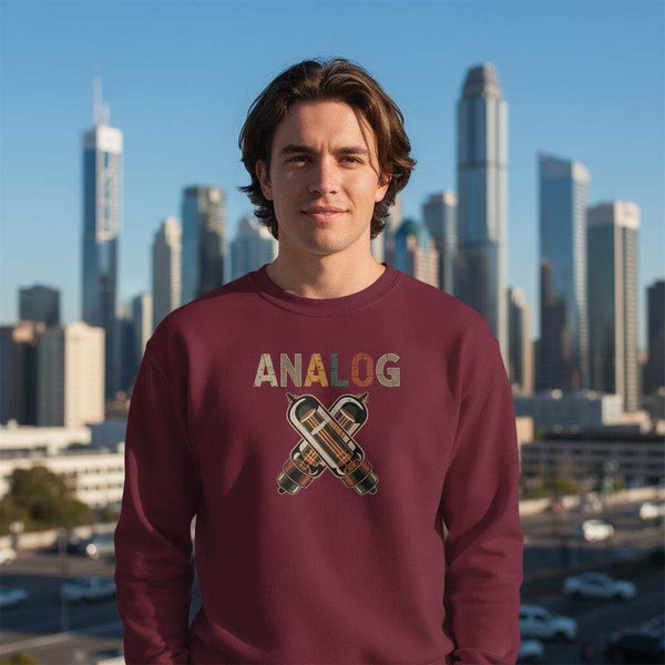 Mann trägt kuscheligen Komfortpullover Analog in Bordeauxrot vor Stadtkulisse