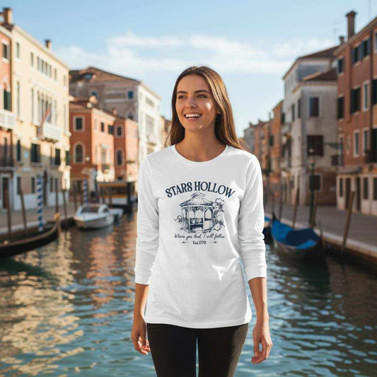 Frau trägt gemütliches Gilmore Girl Langarmshirt mit Stars Hollow Motiv in urbanem Kanalhintergrund